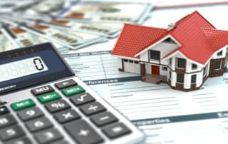 Calculator, house model, and financial documents