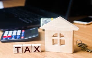 Calculator and house blocks representing tax calculation.