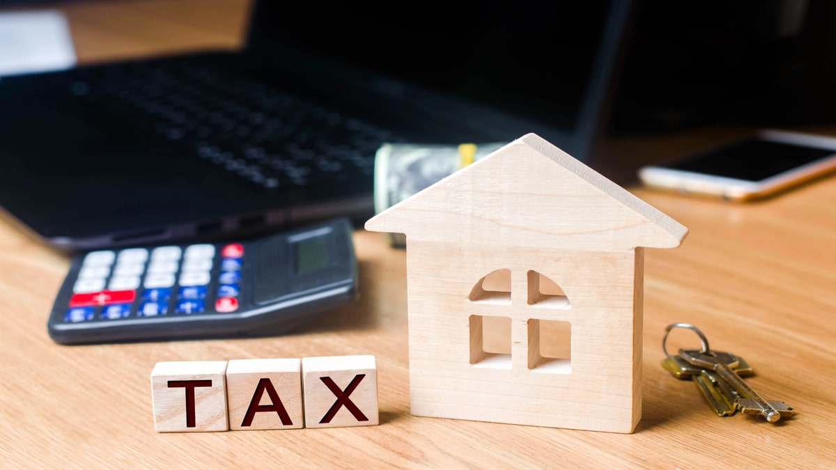 Tax Implications of Hard Money Lending for Investors Calculator and house blocks representing tax calculation.