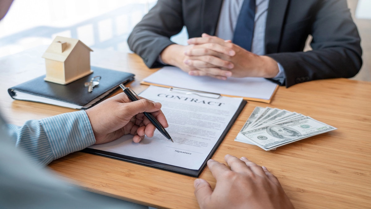 Wholesale Real Estate Using Hard Money for Quick Property Acquisitions Signing contract with money and house model